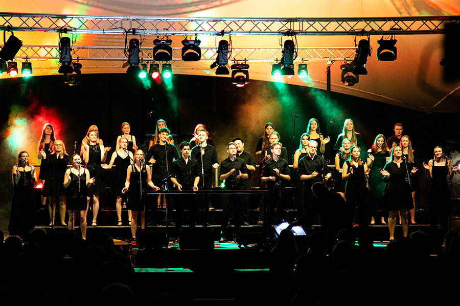 Der Erwitter Jugendchor Voices in Harmony auf einer bunt beleuchteten Konzertbühne